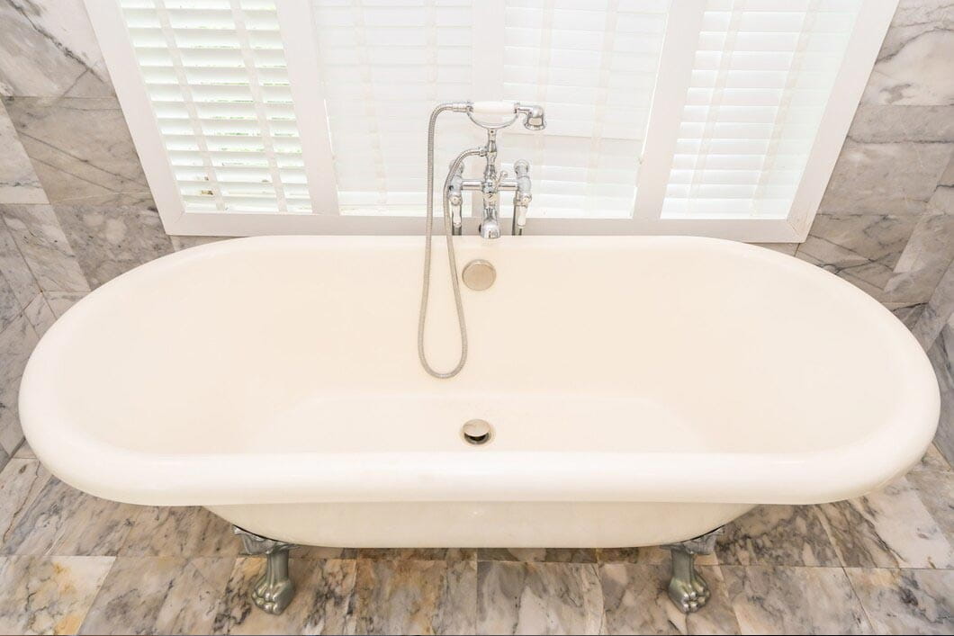 Freestanding bathtub with shower faucet and handheld shower fixture